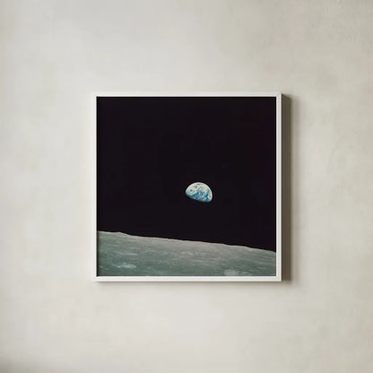 First Earth Rise by Wild Apple Portfolio. Shown in a crisp white glass frame for a clean and minimalist style. Available as an archival giclee rolled canvas, fine art paper, or poster print. SKU 84536a.