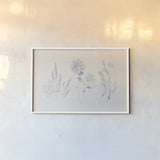 Flowers on White VIII Blue by Wild Apple Portfolio. shown as a paper print in a white frame. Available as a archival giclee rolled canvas, fine art paper, or poster print. SKU 78211i.