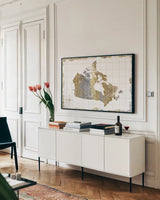Gilded Map Canada by Wild Apple Portfolio. shown as a framed stretched canvas in a living room above a console. Available as a archival giclee rolled canvas, fine art paper, or poster print. SKU 41345i.