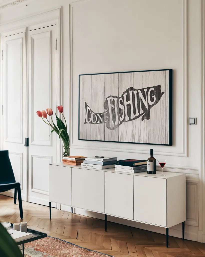 Gone Fishing Sign by Wild Apple Portfolio. shown as a framed stretched canvas in a living room above a console. Available as a archival giclee rolled canvas, fine art paper, or poster print. SKU 72461i.