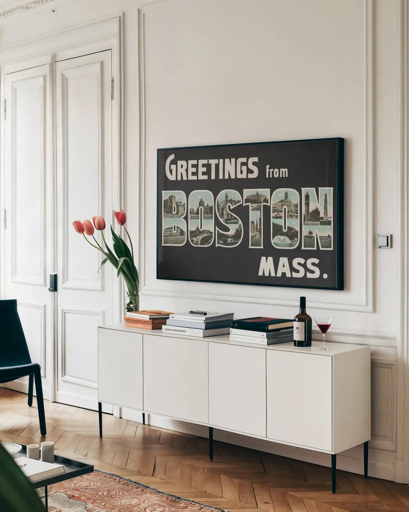 Greetings from Boston by Wild Apple Portfolio. shown as a framed stretched canvas in a living room above a console. Available as a archival giclee rolled canvas, fine art paper, or poster print. SKU 89471i.