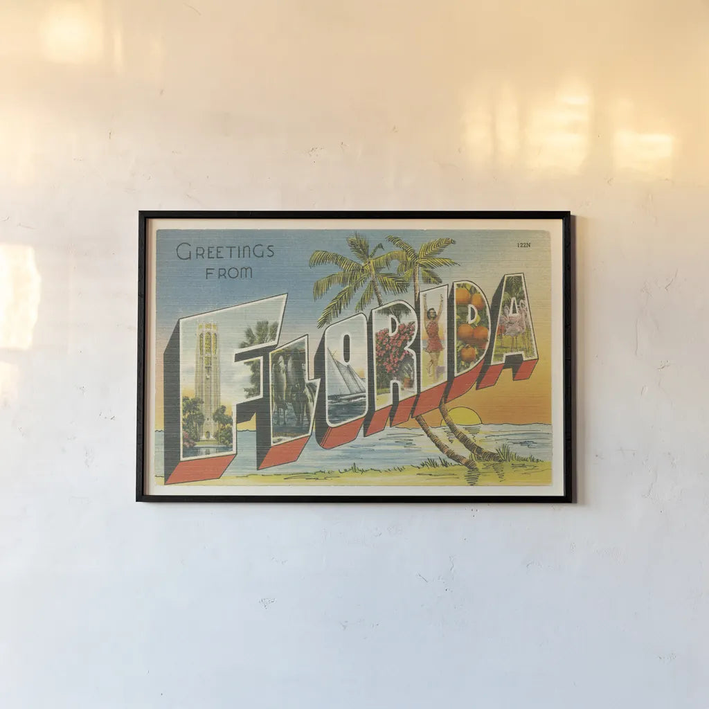 Greetings from Florida v2 by Wild Apple Portfolio. shown as a paper print in a black flame. Available as a archival giclee rolled canvas, fine art paper, or poster print. SKU 45241i.