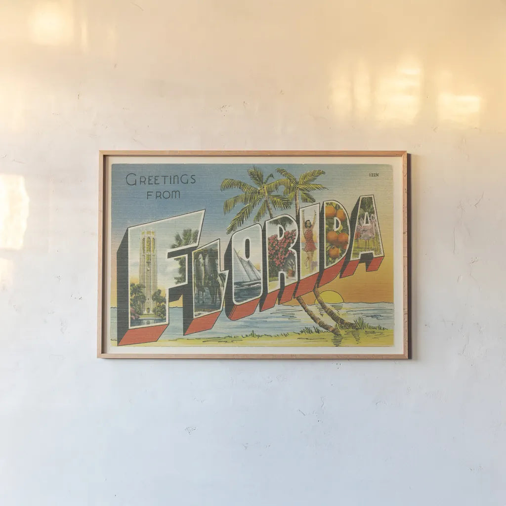 Greetings from Florida v2 by Wild Apple Portfolio. shown as a paper print in a natural frame. Available as a archival giclee rolled canvas, fine art paper, or poster print. SKU 45241i.
