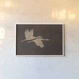 Herons in Flight Mocha by Wild Apple Portfolio. shown as a paper print in a white frame. Available as a archival giclee rolled canvas, fine art paper, or poster print. SKU 96471i.