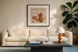 Latte on Linen by Wild Apple Portfolio. Displayed in a glass frame with matte in a clean modern living room. Available as an archival giclee rolled canvas, fine art paper, or poster print. SKU 39918a.