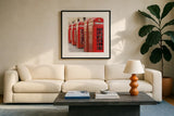 London Phoneboxes by Wild Apple Portfolio. Displayed in a glass frame with matte in a clean modern living room. Available as an archival giclee rolled canvas, fine art paper, or poster print. SKU 73353a.
