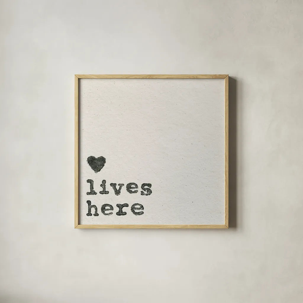 Love Lives Here by Wild Apple Portfolio. Shown in a natural wood glass frame for a timeless modern aesthetic. Available as an archival giclee rolled canvas, fine art paper, or poster print. SKU 71691a.