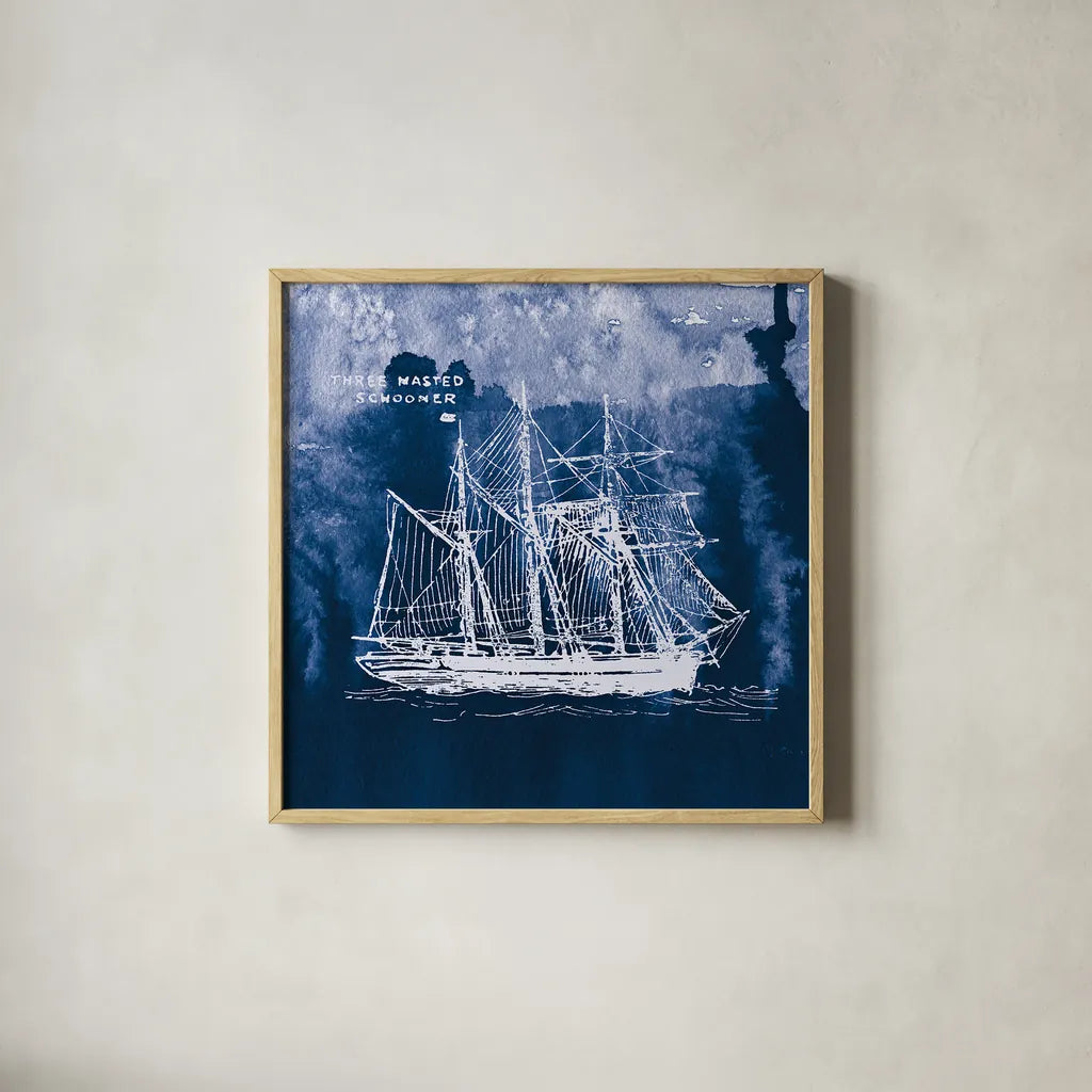 Sailing Ships II Indigo by Wild Apple Portfolio. Shown in a natural wood glass frame for a timeless modern aesthetic. Available as an archival giclee rolled canvas, fine art paper, or poster print. SKU 32099a.
