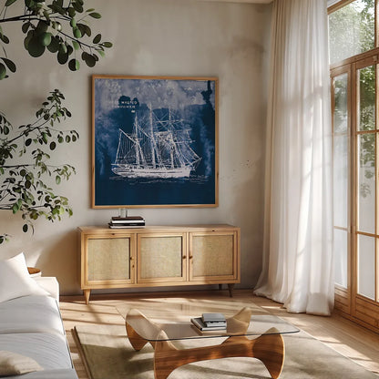 Sailing Ships II Indigo by Wild Apple Portfolio. Shown in a natural wood frame in a cozy modern living room. Available as an archival giclee rolled canvas, fine art paper, or poster print. SKU 32099a.