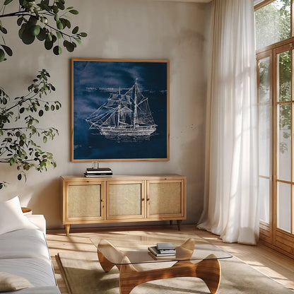 Sailing Ships V Indigo by Wild Apple Portfolio. Shown in a natural wood frame in a cozy modern living room. Available as an archival giclee rolled canvas, fine art paper, or poster print. SKU 32102a.