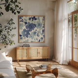 Soft Blue Florals II by Wild Apple Portfolio. Shown in a natural wood frame in a cozy modern living room. Available as an archival giclee rolled canvas, fine art paper, or poster print. SKU 56490a.