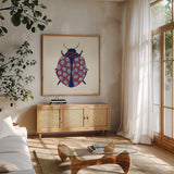 Blooming Beetle I by Yvette St. Amant. Shown in a natural wood frame in a cozy modern living room. Available as an archival giclee rolled canvas, fine art paper, or poster print. SKU 90895a.