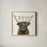Highland Cow Clothesline by Yvette St. Amant. Shown in a natural wood glass frame for a timeless modern aesthetic. Available as an archival giclee rolled canvas, fine art paper, or poster print. SKU 89452a.